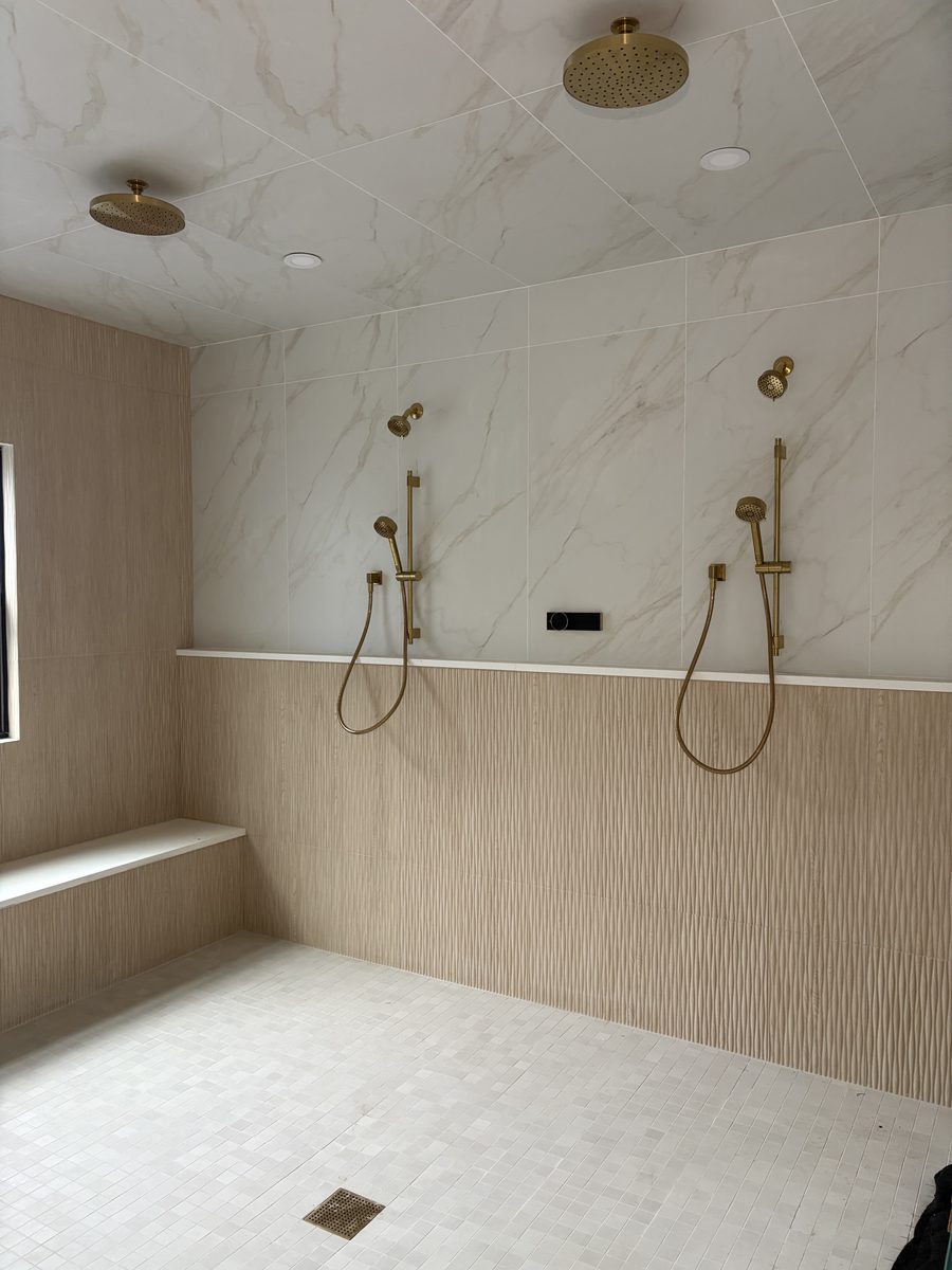 Custom tile shower with brass fixtures installed by Above All Services Plumbing